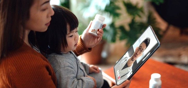 woman looking at tablet with child